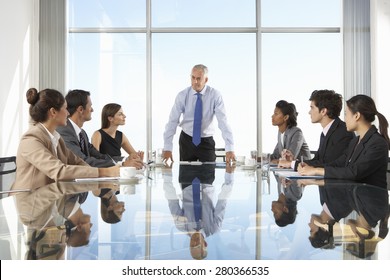 Group Of Business People Having Board Meeting Around Glass Table