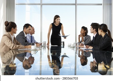 Group Of Business People Having Board Meeting Around Glass Table