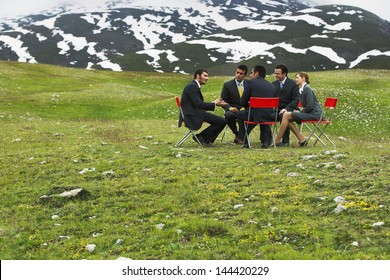 Group Of Business People Having Conference In Mountain Field