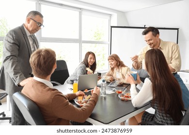 Group of business people having lunch in office - Powered by Shutterstock