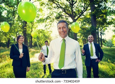 Group Of Business People Holding Balloons In The Forest.