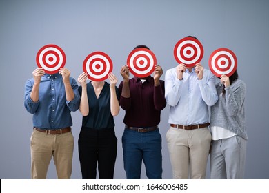 Group Of Business People Holding A Target Against Their Faces