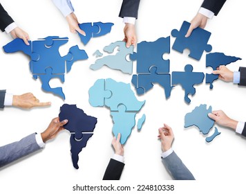 Group Of Business People With Jigsaw Puzzle Forming In World Map