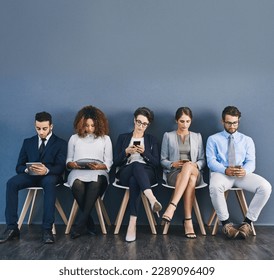 Group of business people at a job interview at a small startup company with copy space. Businesspeople sitting and waiting in line for a meeting with human resources and applying for work - Powered by Shutterstock