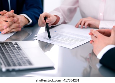 Group of business people and lawyers discussing contract papers sitting at the table, close up
