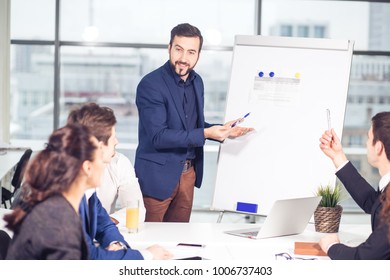 Group Of Business People Looking At The Graph On Flipchart