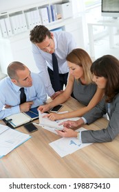 Group Of Business People Meeting Around Table With Tablet