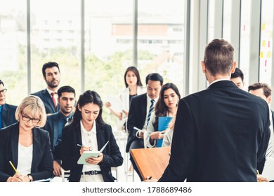 Group Of Business People Meeting In A Seminar Conference . Audience Listening To Instructor In Employee Education Training Session . Office Worker Community Summit Forum With Expert Speaker .