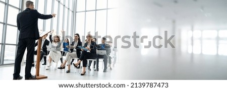 Group of business people meeting in a seminar conference widen view . Audience listening to instructor in employee education training session . Office worker community summit forum with speaker .
