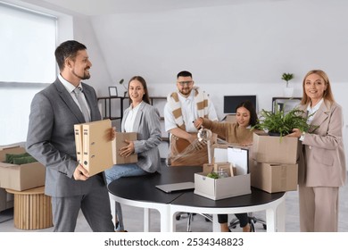 Group of business people packing things in office on moving day - Powered by Shutterstock