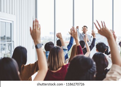 Group of business people raise hands up to agree with speaker in the meeting room seminar - Powered by Shutterstock