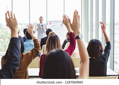 Group of business people raise hands up to agree with speaker in the meeting room seminar - Shutterstock ID 1187069845