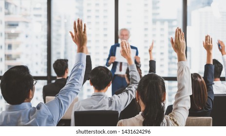 Group of business people raise hands up to ask question and answer to speaker in the meeting room seminar - Shutterstock ID 1431624296
