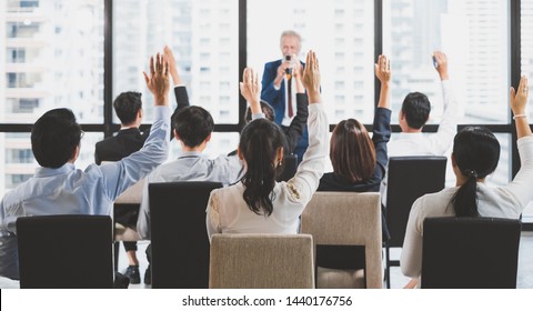 Group Of Business People Raise Hands Up To Ask Question And Answer To Speaker In The Meeting Room Seminar