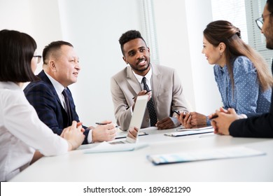 Group of business people sitting around the office desk and discussing the project together - Shutterstock ID 1896821290