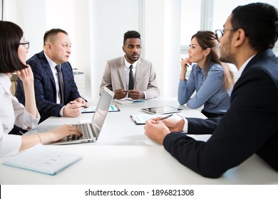 Group of business people sitting around the office desk and discussing the project together - Powered by Shutterstock