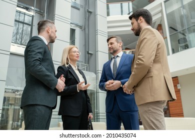 Group of business people talking to each other while meeting together at office corridor - Shutterstock ID 2010435074