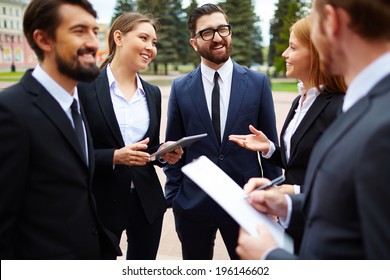 Group Of Business People Talking At Meeting Outside