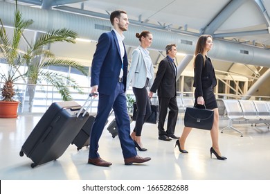 Group Of Business People As A Business Team Arriving At The Airport Terminal