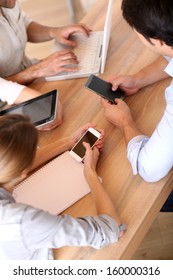 Group Of Business People Using Electronic Devices At Work