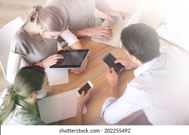 Group Of Business People Using Electronic Devices At Work