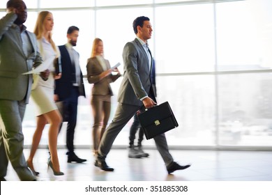 Group Of Business People Walking In The Corridor