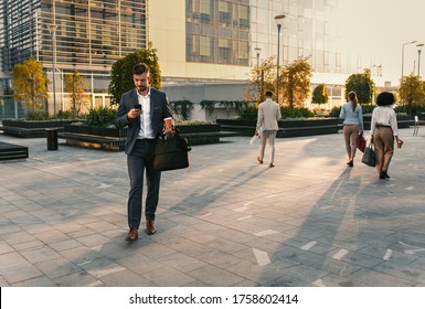 Group Of Business People Walking Outside In Front Of Office Buildings.