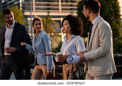 Group Of Business People Walking Outside In Front Of Office Buildings.