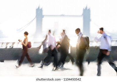 Group Of Business People Walking Over London Bridge To The City Of London. Early Morning Rush, Modern Life Concept