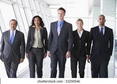 Group Of Business People Walking Through Office Towards Camera