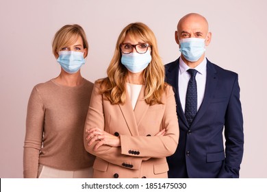 Group Of Business People Wearing Face Masks And Looking At Camera While Standing Together At Isolated Background. 