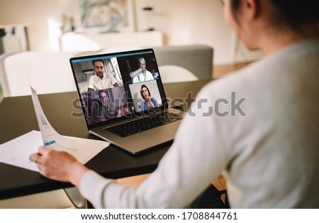 Group of business people working from home, having video conference. Businesswoman having a video call with her team over a laptop at home.