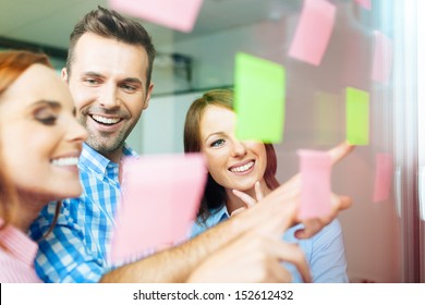 Group of business people working on new project with many sticky notes on window - Powered by Shutterstock