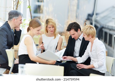 Group Of Business People Working In Team Outdoors In A Coffee Shop