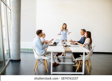 Group Of Business People With Young Adults And Senior Woman Colleague On Meeting At The Modern Bright Office Interior