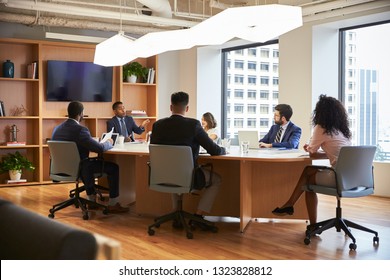 Group Of Business Professionals Meeting Around Table In Modern Office