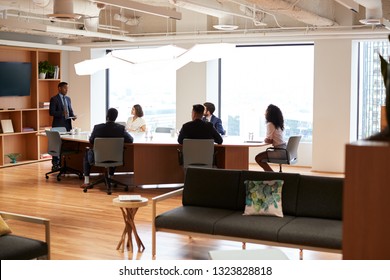 Group Of Business Professionals Meeting Around Table In Modern Office - Shutterstock ID 1323828818