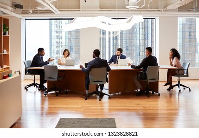 Group Of Business Professionals Meeting Around Table In Modern Office