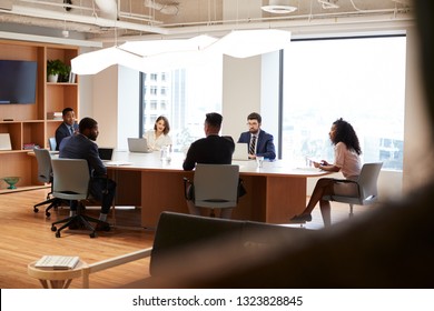 Group Of Business Professionals Meeting Around Table In Modern Office