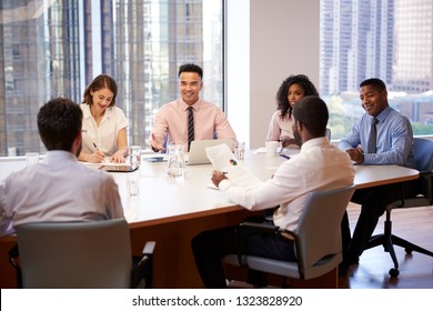 Group Of Business Professionals Meeting Around Table In Modern Office