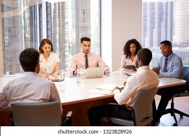 Group Of Business Professionals Meeting Around Table In Modern Office