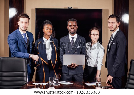 group of business team standing in meeting rom and looking at camera