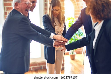 Group of business workers smiling happy and confident. Standing on a circle with smile on face and hands together at the office. - Shutterstock ID 1621797157