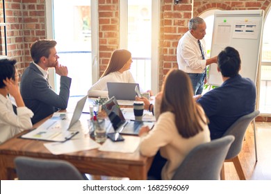 Group Of Business Workers Working Together In A Meeting. One Of Them Making Presentation To Colleagues At The Office