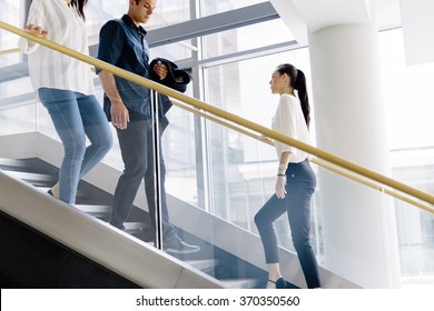 Group of businessman walking and taking stairs in an office building