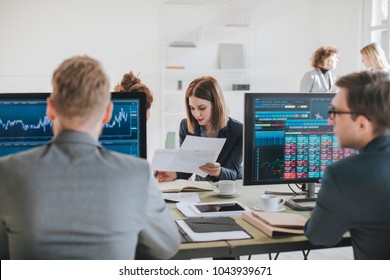 Group Of Businessmen And Businesswomen Stock Brokers Working At Office.