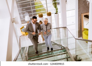 Group of businessmen and businesswomen walking and taking stairs in an office building