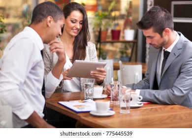 Group Of Businesspeople Having Meeting In Coffee Shop