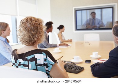 Group Of Businesspeople Having Video Conference In Boardroom