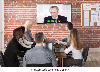 Group Of Businesspeople Having Video Conference In Boardroom